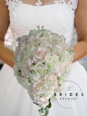 Handmade teardrop wedding bouquet of artificial roses and baby’s breath