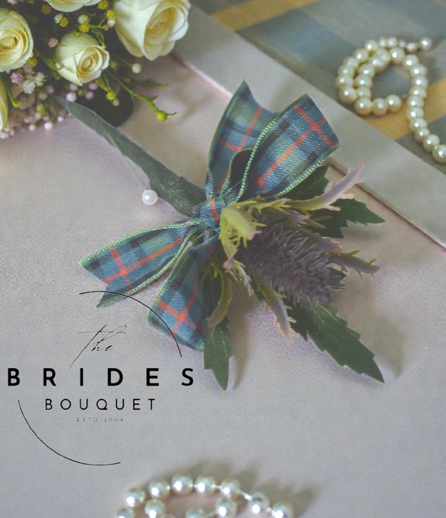 purple small thitsle artificial buttonhole with tartan bow for scottish weddings