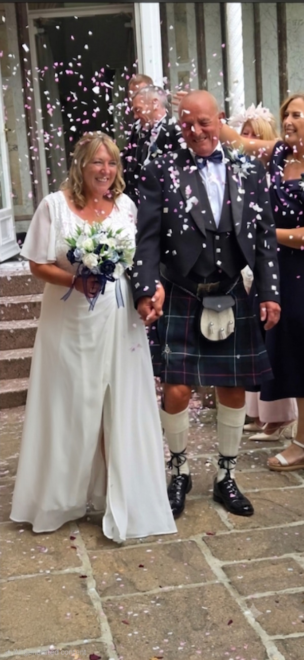 bride and groom with wedding flowers by the brides bouquet uk scottish weddings