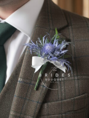 Artificial blue thistle wedding buttonhole with sea holly and ribbon bow