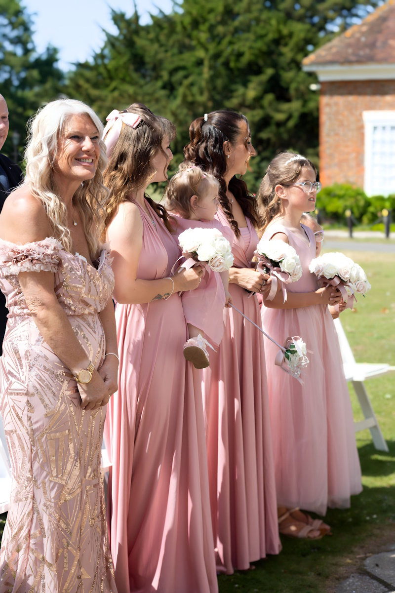 bridesmaids at real life wedding in rose gold with flowers created by the brides bouquet uk