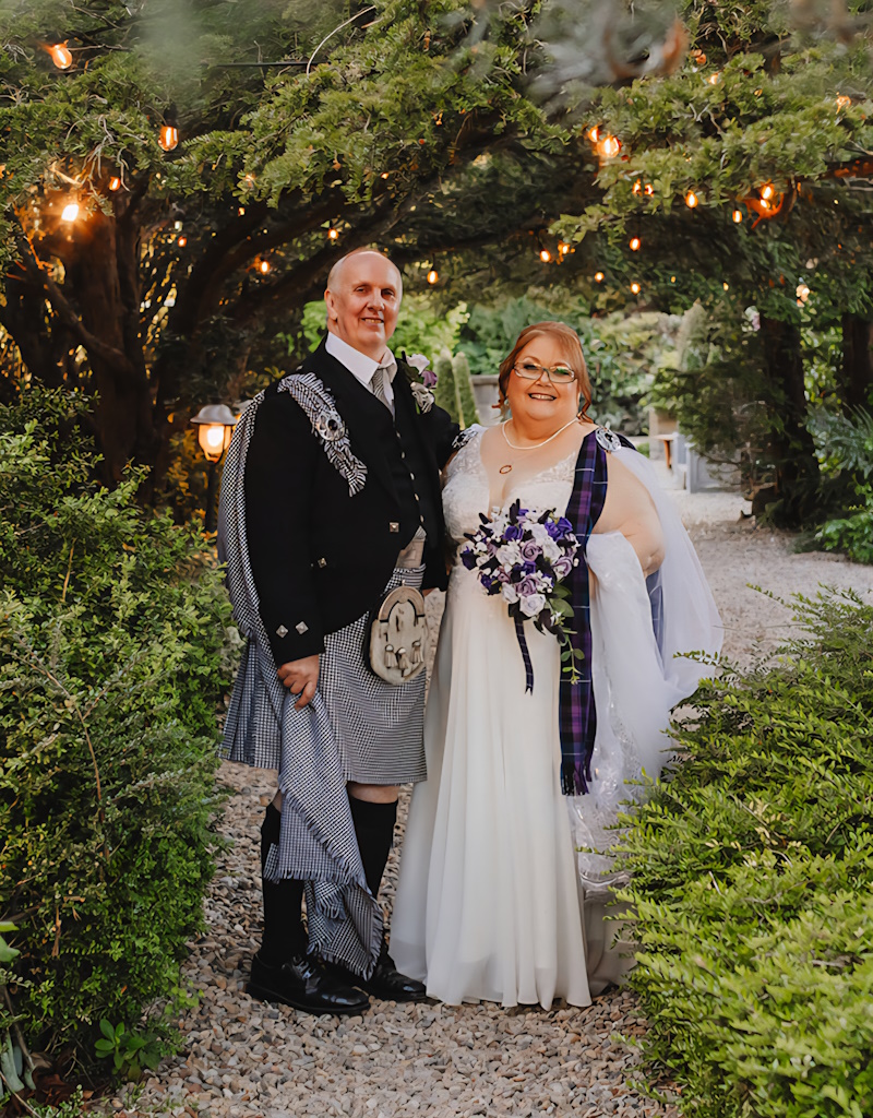 stunning real life wedding review photo of scottish bride groom tartan with thistle and rose flowers by the brides bouquet uk highland setting