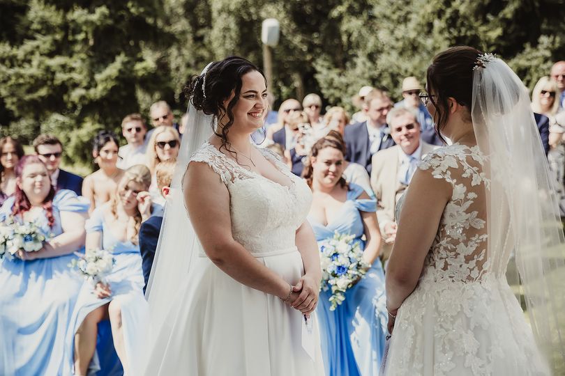 same sex brides with blue wedding flowers by the brides bouquet uk