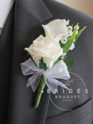 Artificial rose and calla lily groom buttonhole