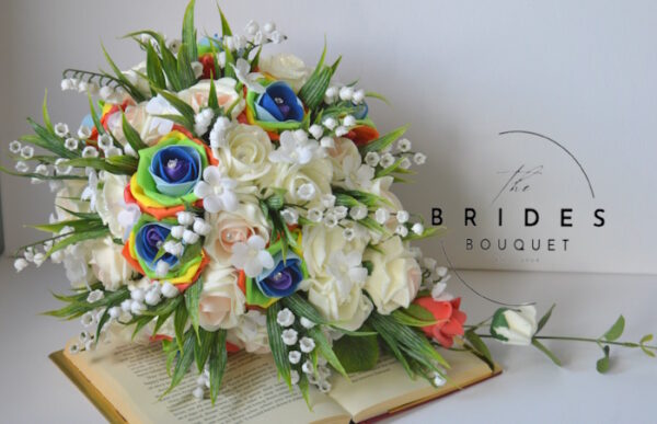 Artificial pride rainbow rose wedding bouquet with lily of the valley – perfect for same-sex weddings and celebrations of love.