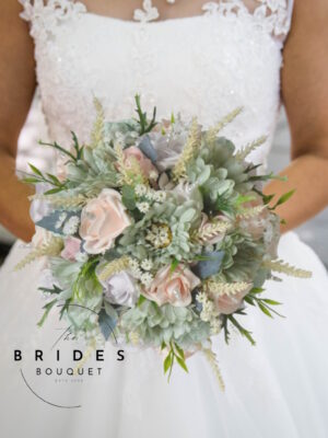 Pastel pink and sage green wedding bouquet with gerbera daisies, roses, heather, and pearl details