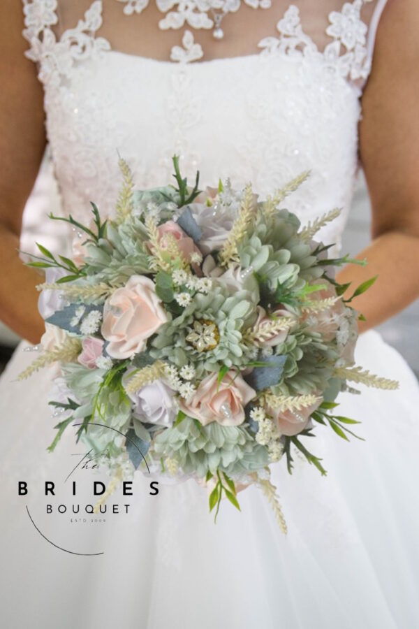 Pastel pink and sage green wedding bouquet with gerbera daisies, roses, heather, and pearl details