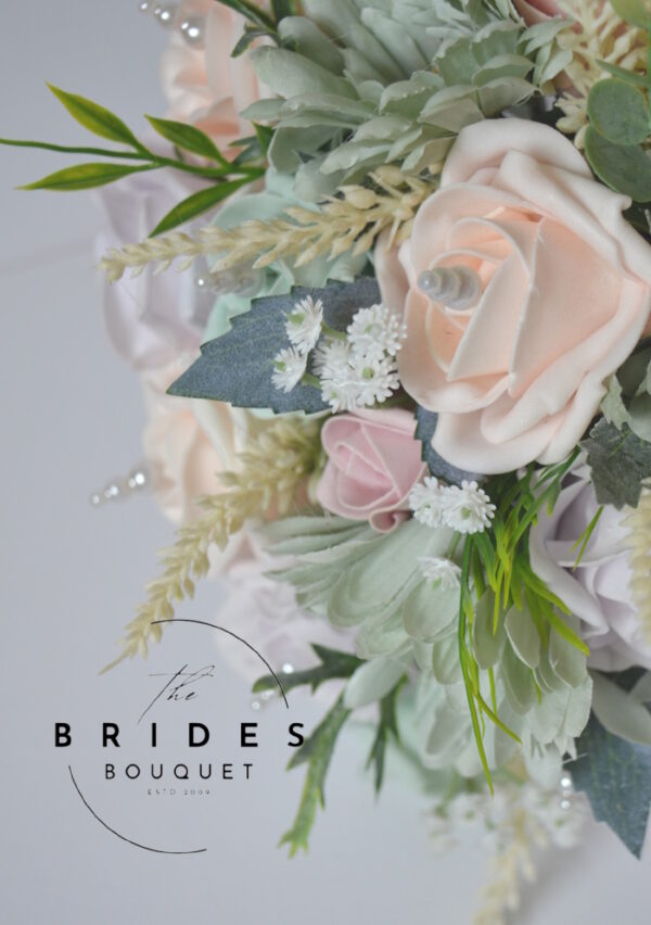 One-of-a-kind pastel pink and sage green bouquet for bride featuring gerberas, roses, and pearls