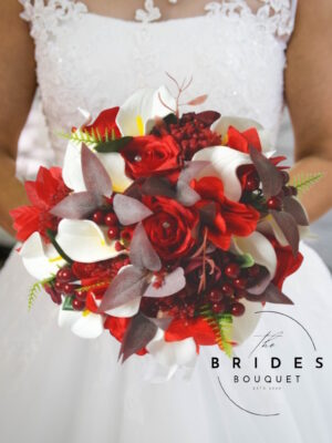 Winter wedding bouquet with red and burgundy silk roses, white calla lilies and poinsettias