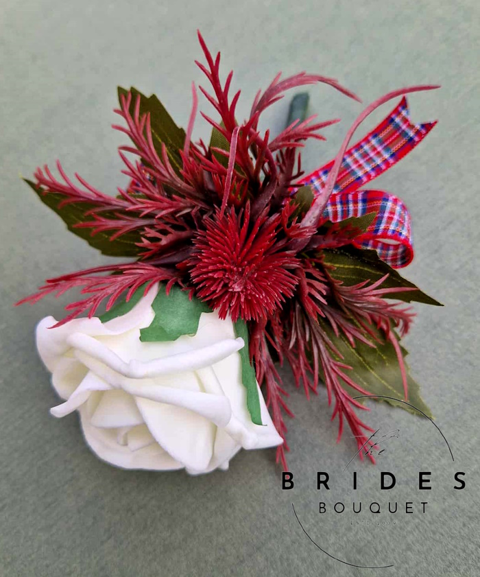 deep red thistle and rose scottish wedding buttonhole artificilal corsage for grooms guests weddings Thistle and rose wedding buttonhole in burgundy and red with artificial eryngium thistle and ribbon bow