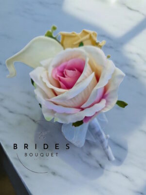 Silk and faux rose wedding buttonhole with calla lily, eucalyptus and lamb’s ear foliage, personalised with ribbon bow