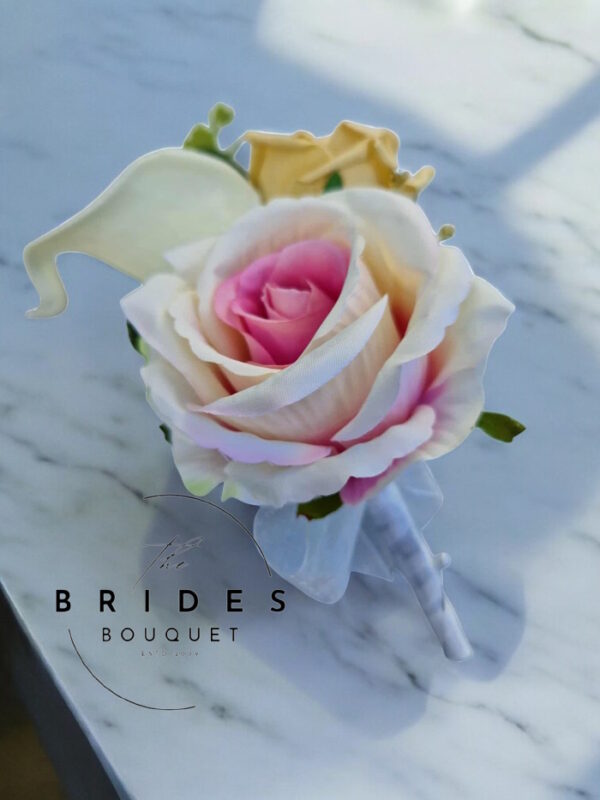 Silk and faux rose wedding buttonhole with calla lily, eucalyptus and lamb’s ear foliage, personalised with ribbon bow