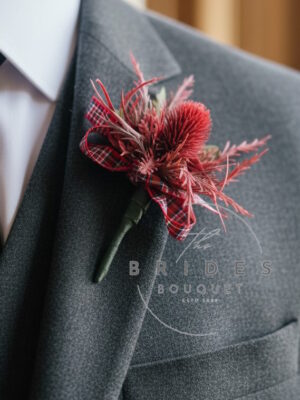 Red thistle wedding buttonhole with artificial sea holly corsage