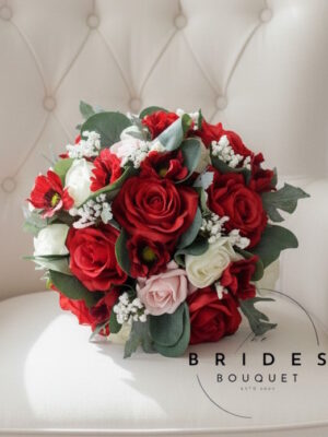 Red silk rose wedding bouquet with pink and ivory glitter accents, ribbon-wrapped handle