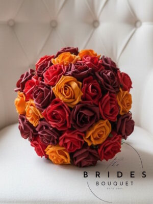 Autumn themed wedding bouquet with orange, red and burgundy artificial foam roses